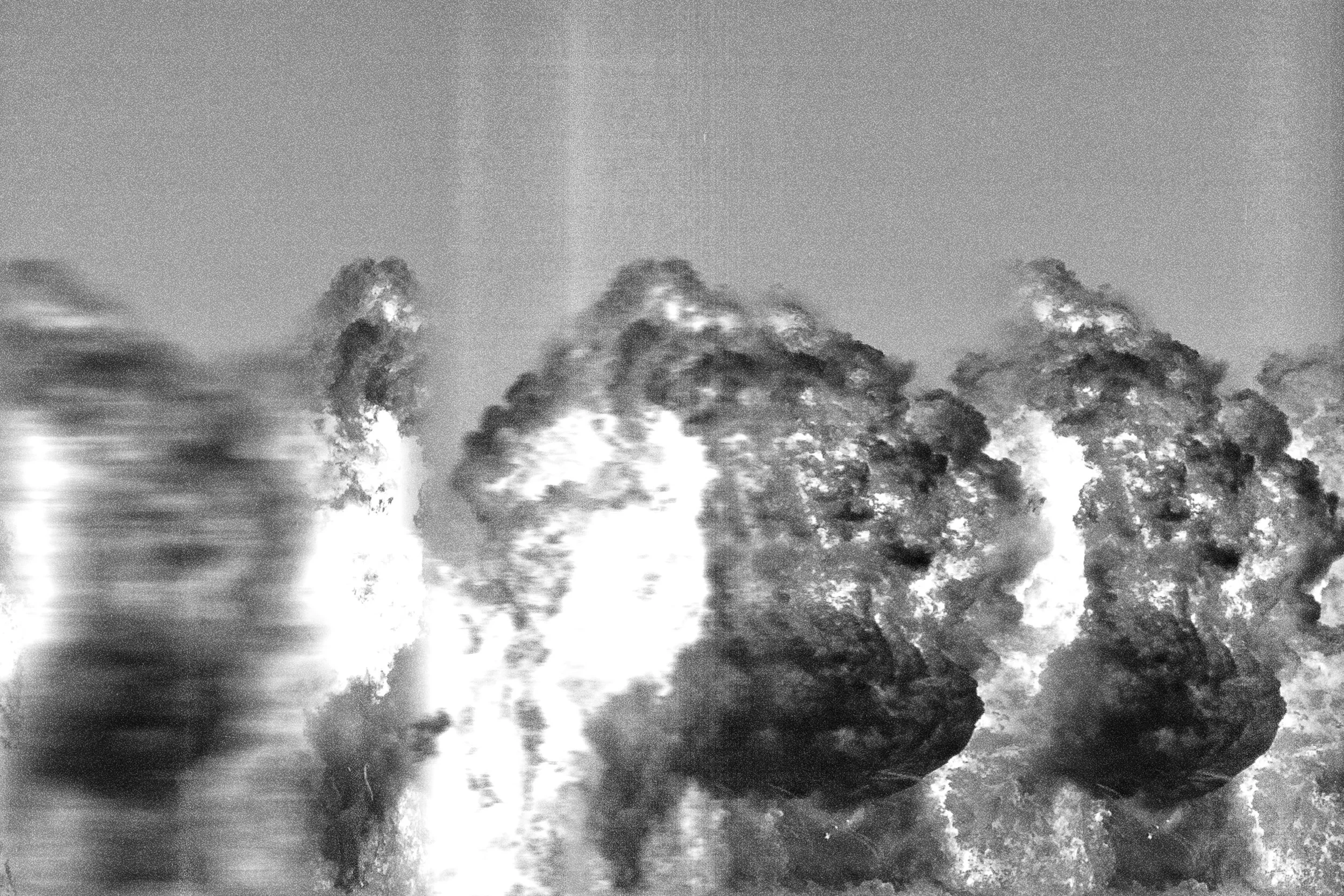 Black and white photograph of clouds or smoke formations with some motion blur on the left side.